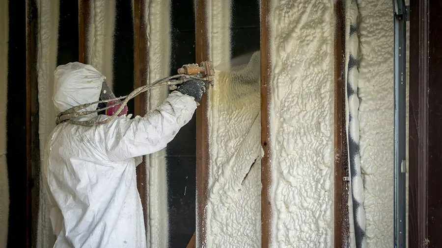 HVAC professional inspecting wall insulation for energy loss and temperature control.