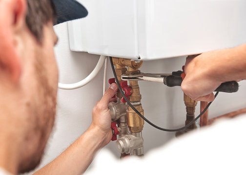 Professional heating technician performing diagnostic check on furnace system